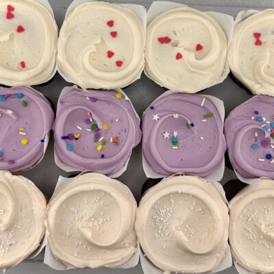 Assorted dozen cupcakes in a bakery box with chocolate with vanilla frosting, strawberry cupcake, and funfetti